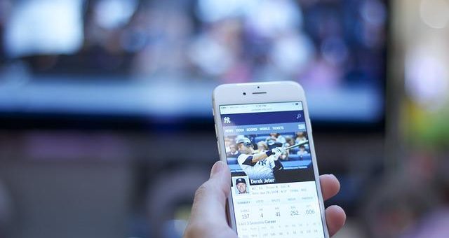 Ein Mann wettet vor einem Baseballspiel.